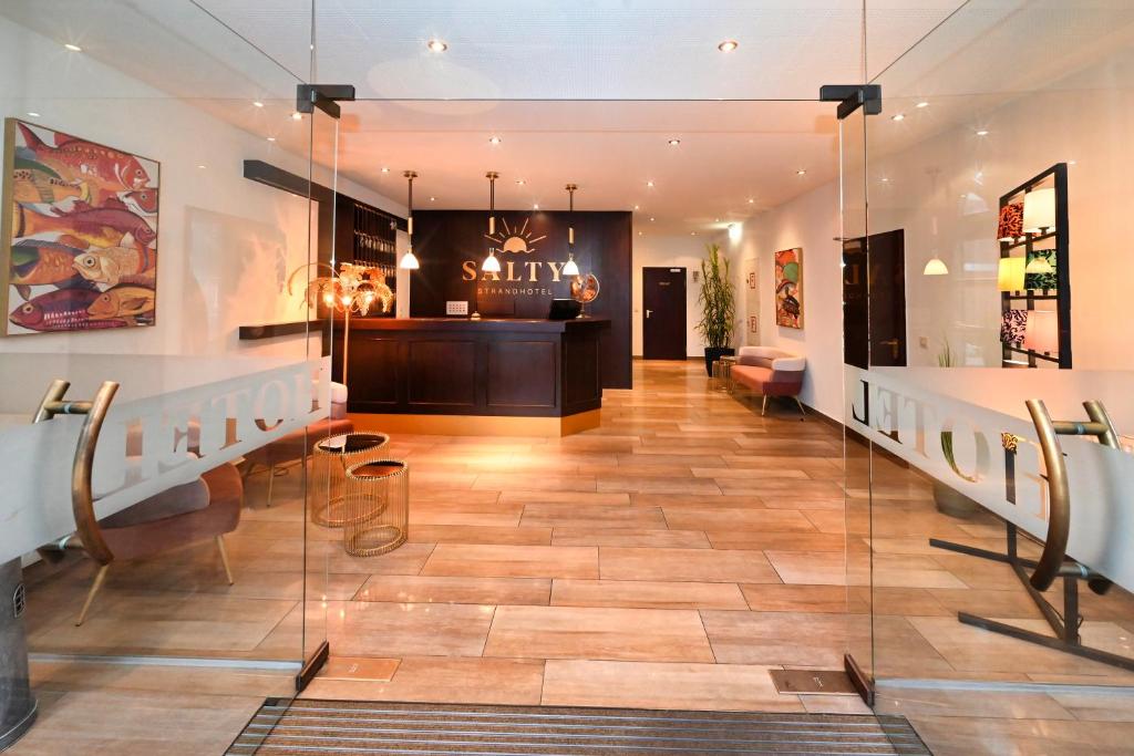 a lobby of a store with glass walls at Strandhotel Salty in Büsum