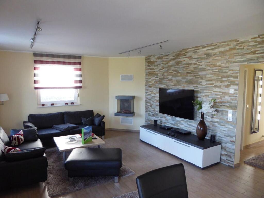 Una sala de estar con un sofá y un televisor de pantalla plana. en Villa Lago am Fleesensee, en Göhren-Lebbin