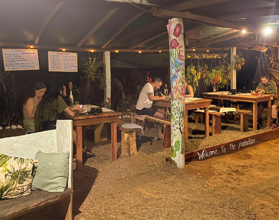 a group of people sitting at tables in a tent at Rio Agujitas Eco-Jungle in Drake