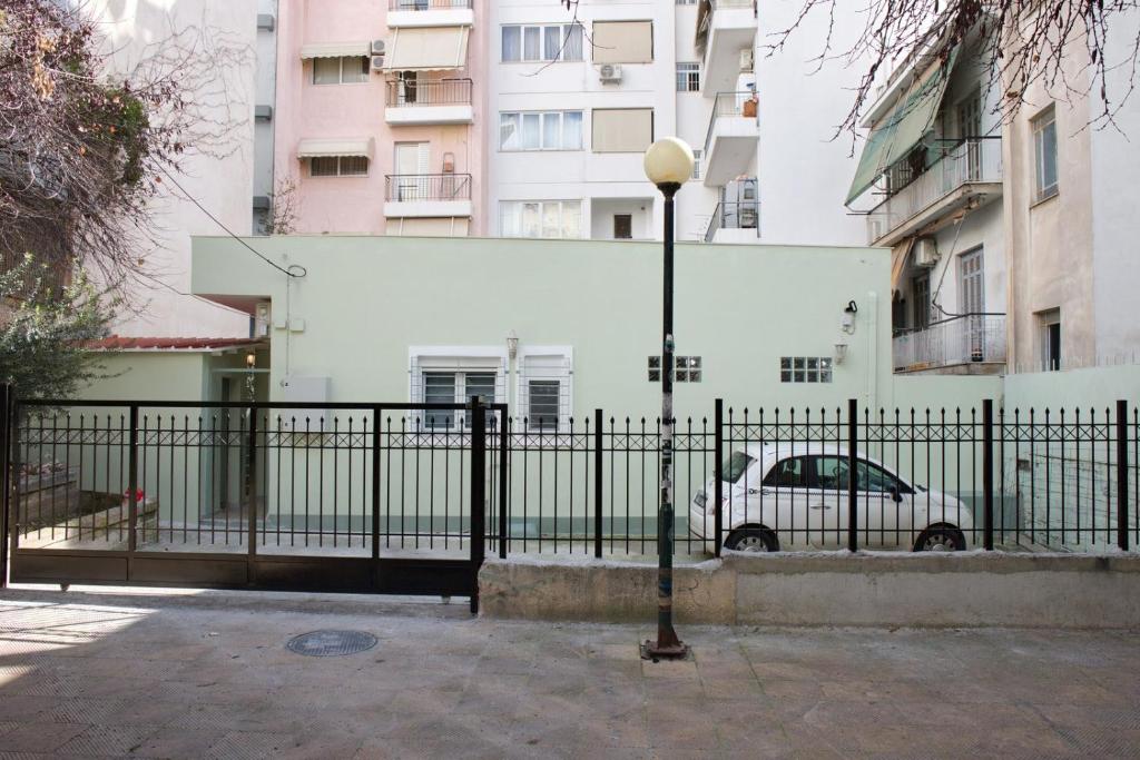 a black fence with a car in front of a building at Aroura Homes Garden House 2BR 2BA Free Parking in Athens