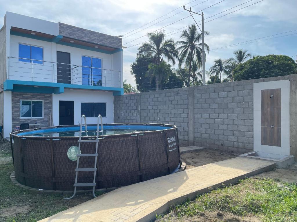 a ladder next to a swimming pool in front of a house at Villa Carolina SM in Santa Marta