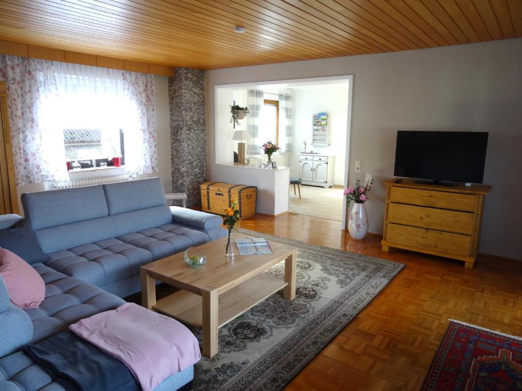 - un salon avec un canapé bleu et une table dans l'établissement Ferienwohnung Dorothea, à Kulmbach