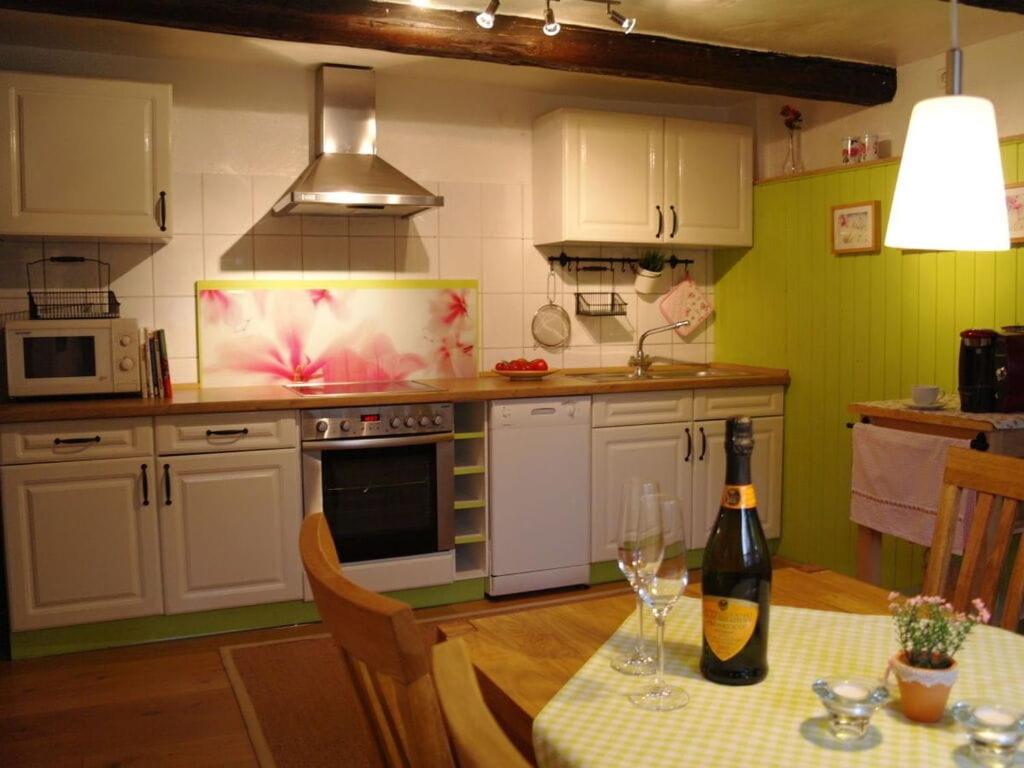 uma cozinha com uma mesa e uma garrafa de vinho em Rauchkate Weibeck em Hessisch Oldendorf
