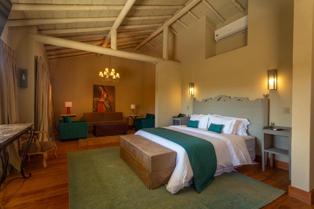 a bedroom with a large bed and a living room at Quinta dos Manacás Pousada - Pedra Azul - Rota dos Lagos in Pedra Azul