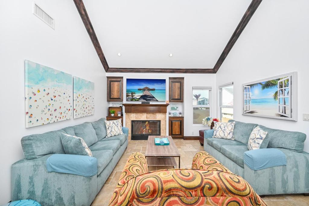sala de estar con sofás azules y chimenea en 3 Bedroom Luxury Home Steps to Balboa Fun Zone, en Newport Beach