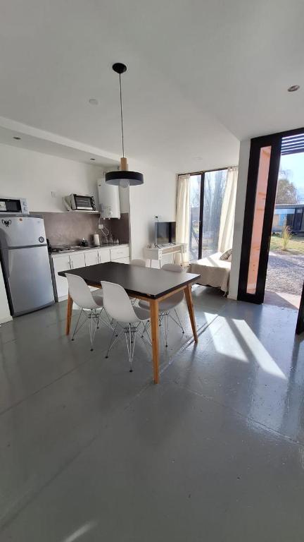 a dining room with a table and chairs in a kitchen at Cubil Naranja. Casa conteiner 2 dormitorios in General Roca