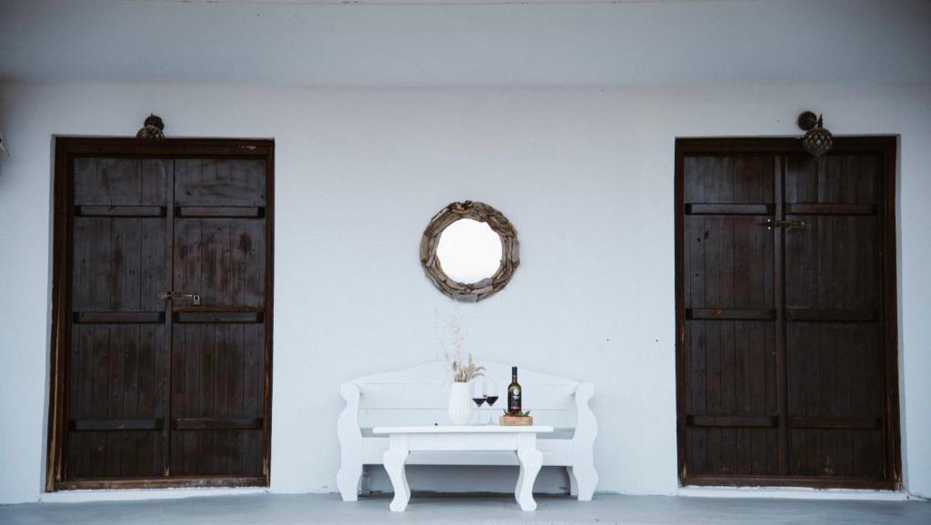 a white room with two doors and a table with a mirror at Villas Gemeli in Ammouliani