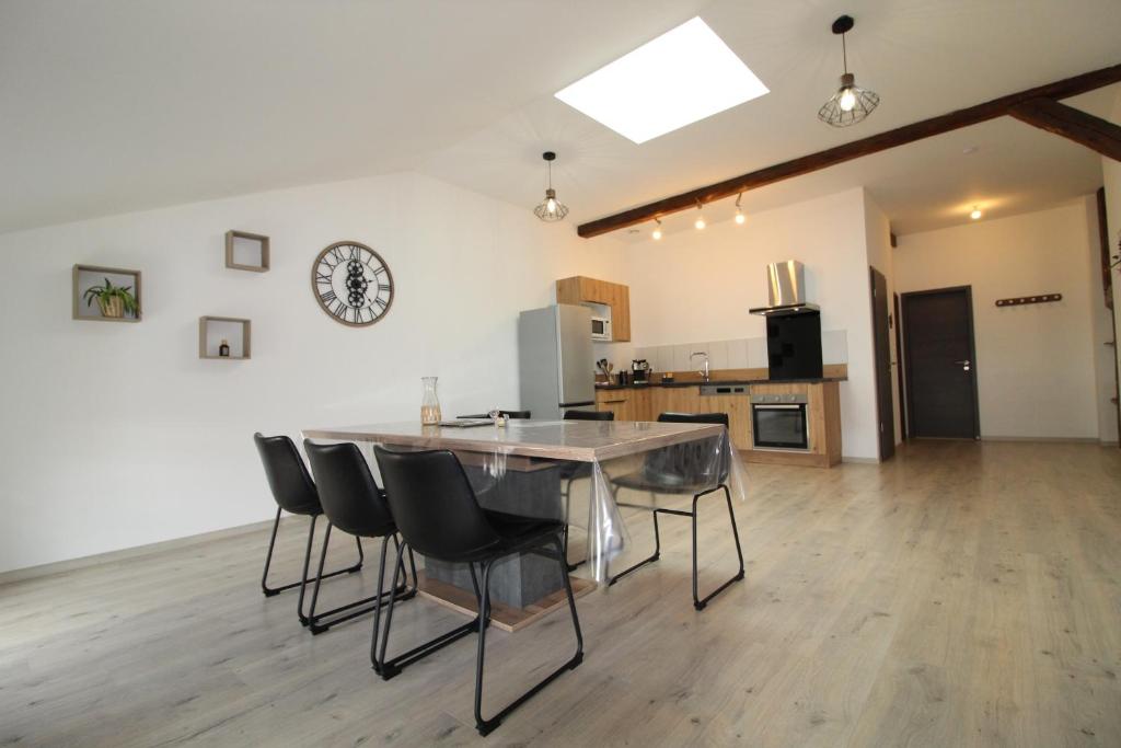 a kitchen and dining room with a table and chairs at L'Avison in Bruyères