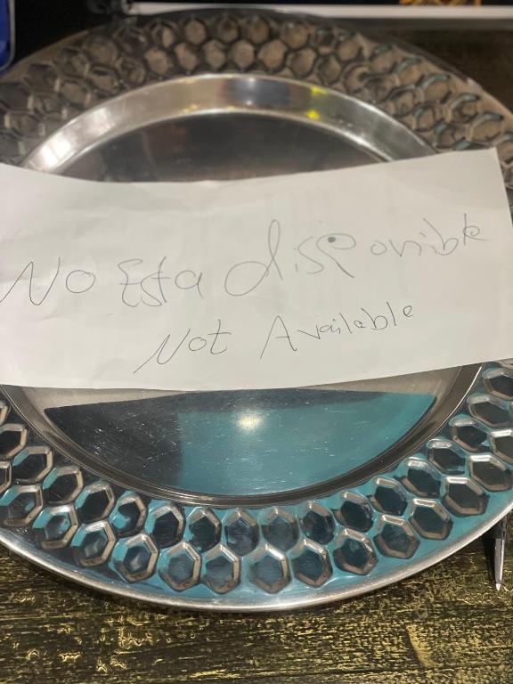 a sign sitting on top of a silver plate at لا متاح in Mexico City