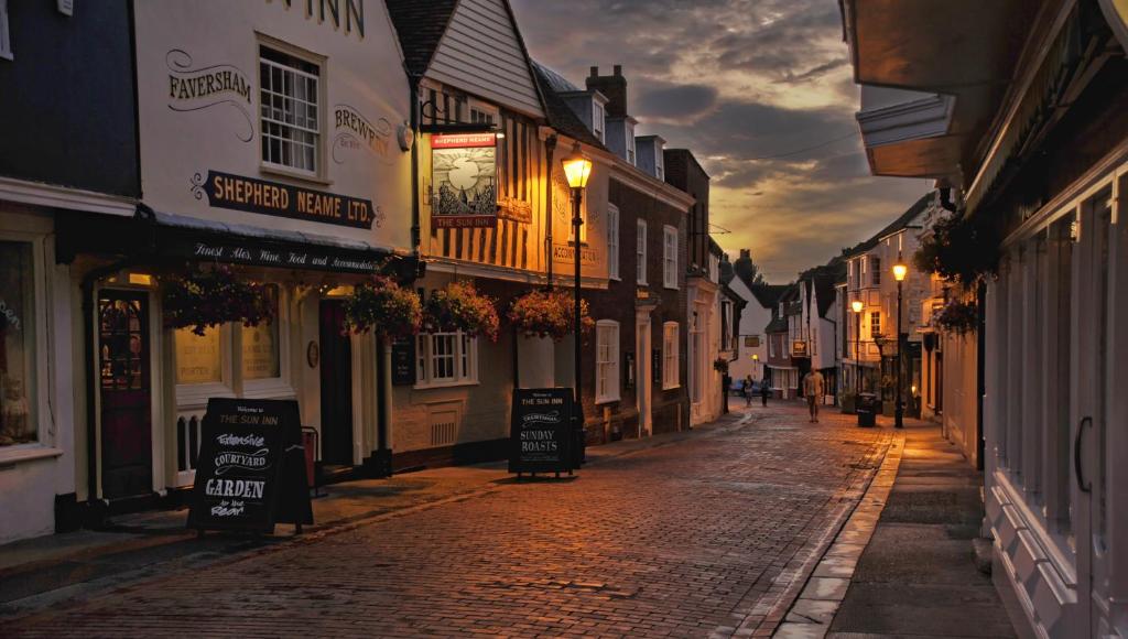 una calle adoquinada en un casco antiguo por la noche en The Sun Inn, en Faversham