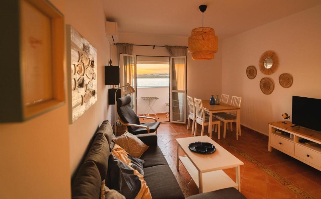 uma sala de estar com um sofá e uma mesa em Apartamento Atardeceres em Ayamonte