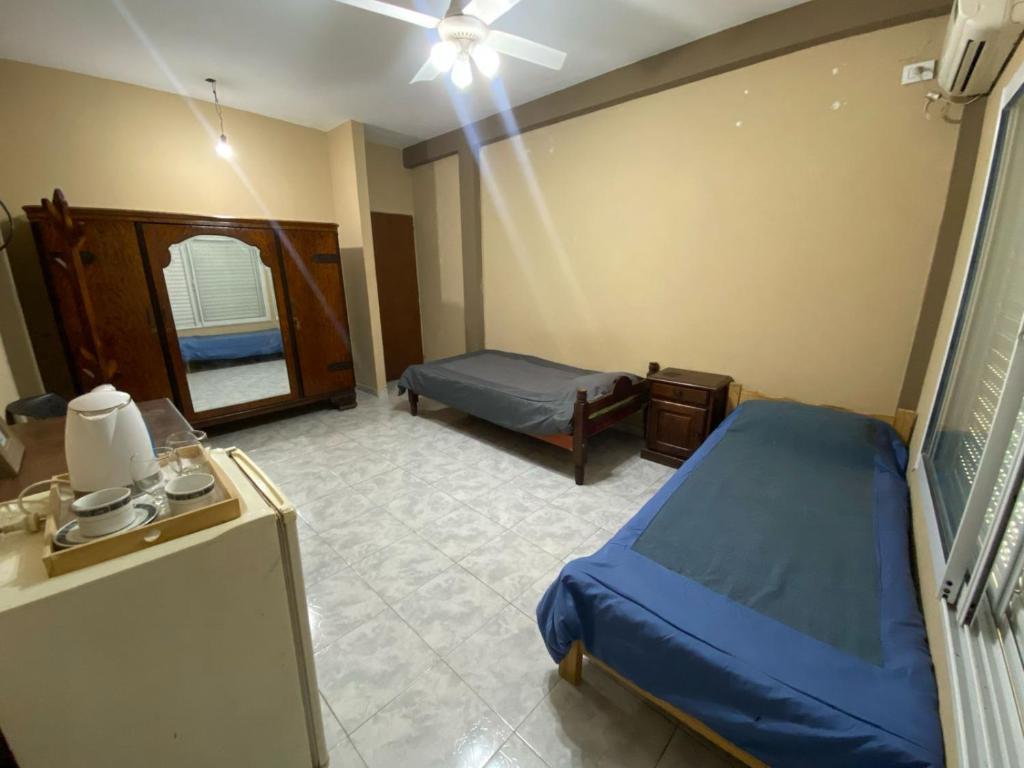 1 dormitorio con cama azul y espejo en LU DORMIS Alquiler Temporario en Corrientes