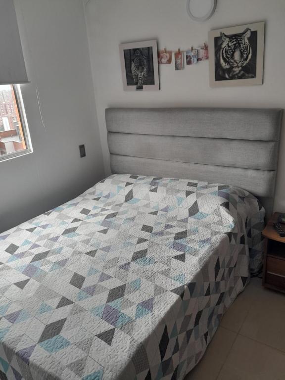 a bedroom with a bed with a quilt on it at Apartamento inigualable en la ciudad de Medellín excelente vista piso 25 in Medellín