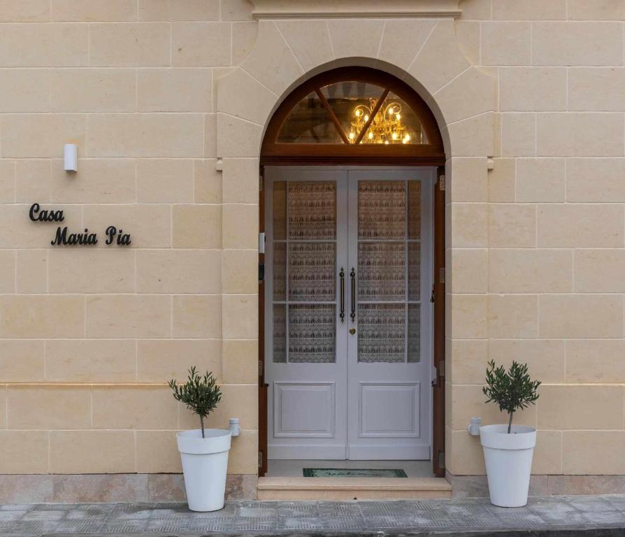 a front door of a building with two potted plants at Casa Maria Pia in Nadur