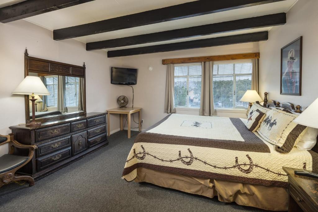 um quarto com uma cama grande e uma televisão em Apache Motel em Moab