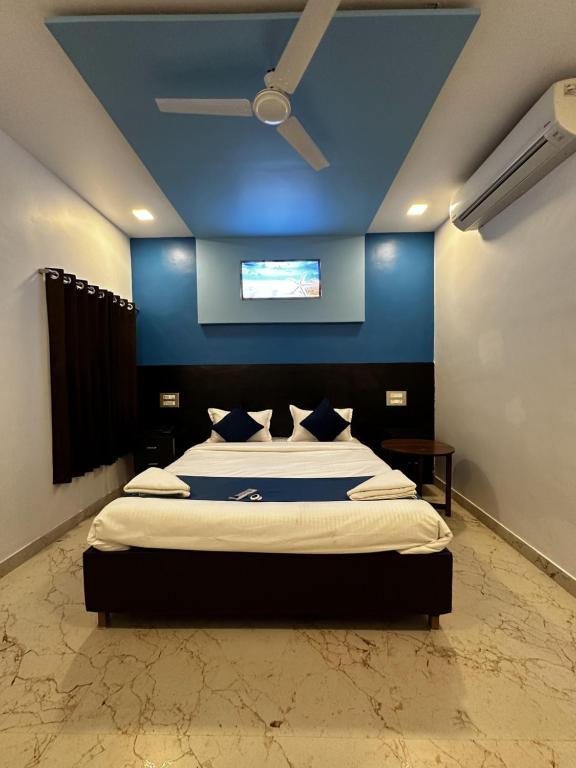 a bedroom with a large bed with a blue wall at Golden Pearl Resort By Gemstone Hospitality in Alibag