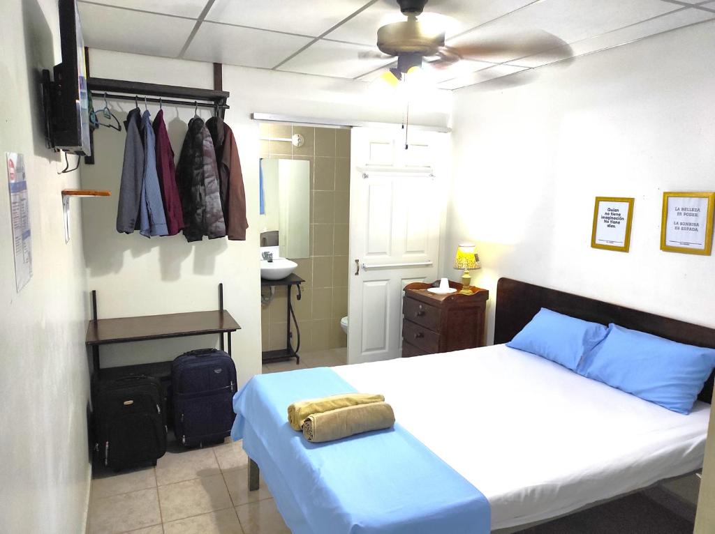 a bedroom with a bed and a ceiling fan at Orison Hostels Managua in Managua