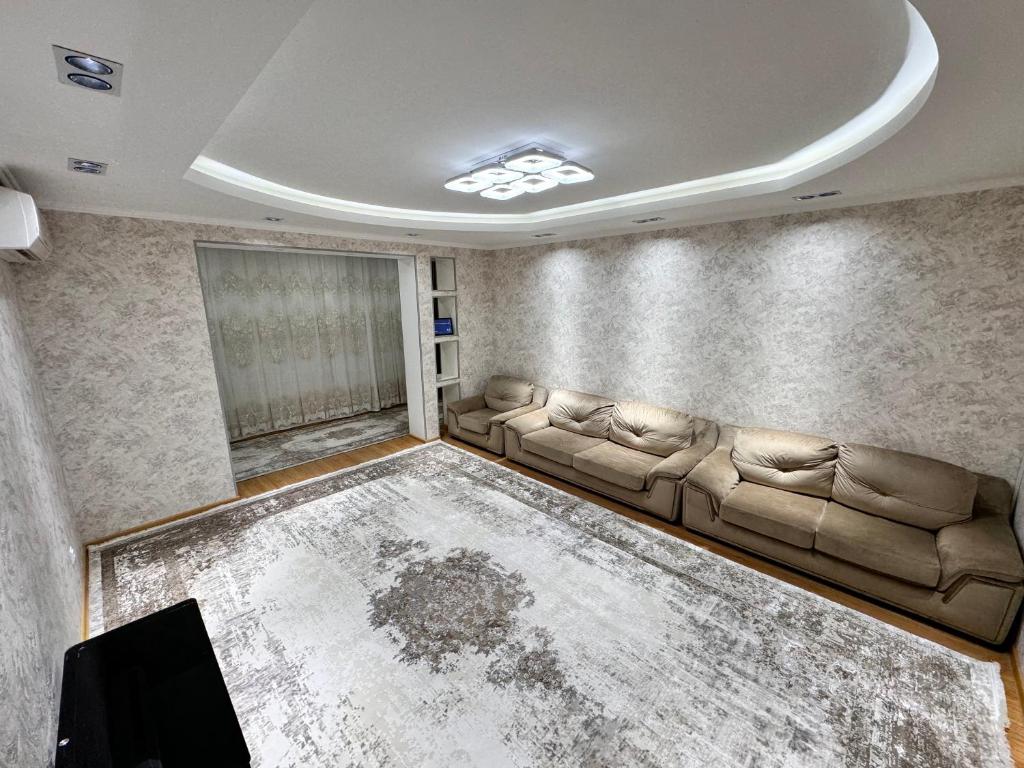 een woonkamer met een bank en een tafel bij Poytakht 80 Apartments in Doesjanbe