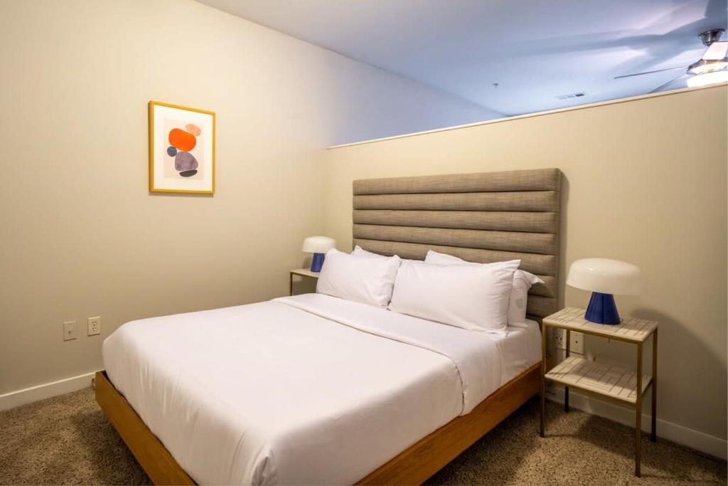 a bedroom with a white bed and a night stand at CozySuites MusicRow Astonishing SDO with free parking 08 in Nashville