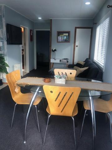 a dining table and chairs in a living room at Clyde Suite in Tauranga