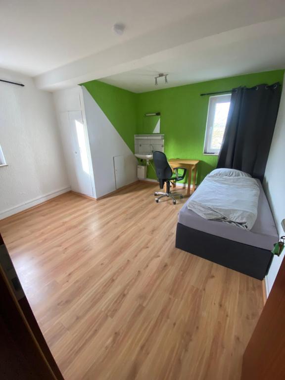 a bedroom with a bed and a desk in a room at Einfache Schlafmöglichkeit mit Gemeinschaftsküche und Bad in Brombachtal