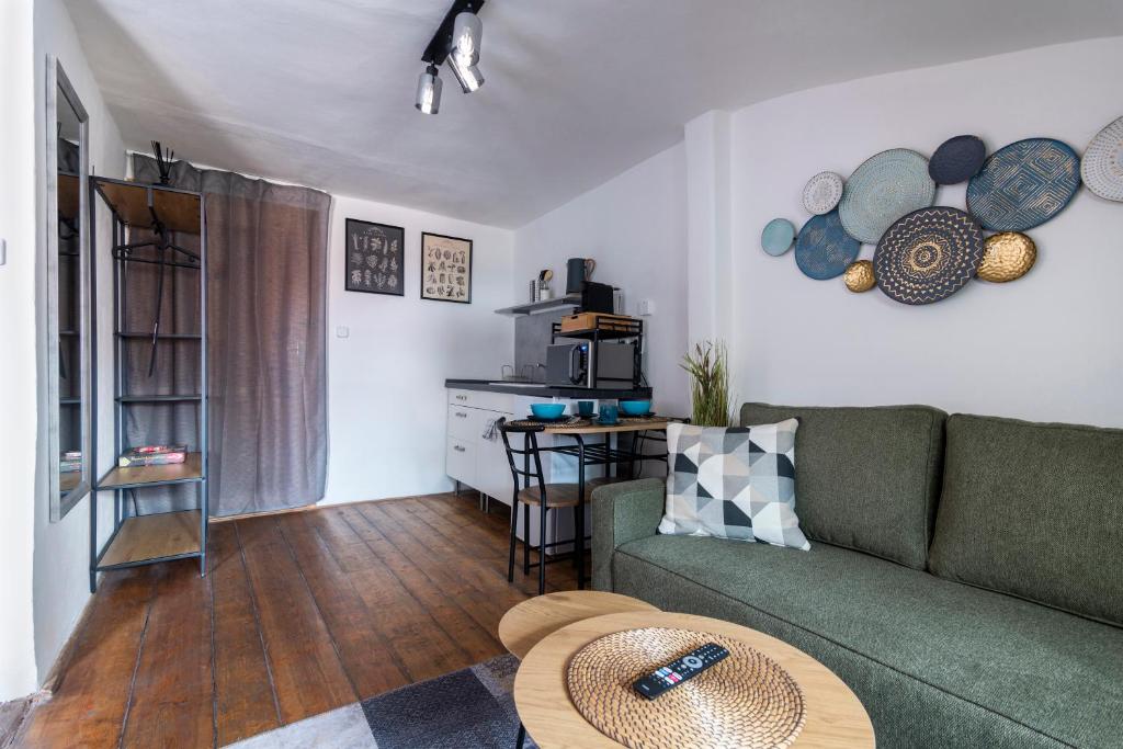 a living room with a green couch and a table at 20 seconds to Charles Bridge in Prague