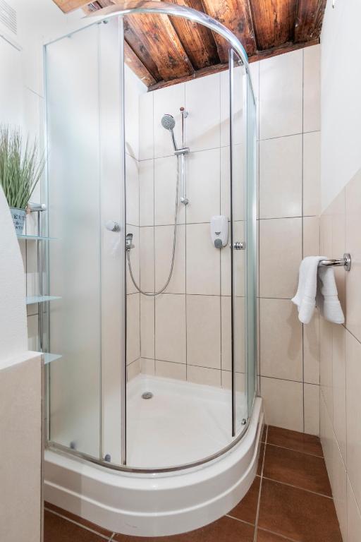 a shower with a glass door in a bathroom at 20 seconds to Charles Bridge in Prague