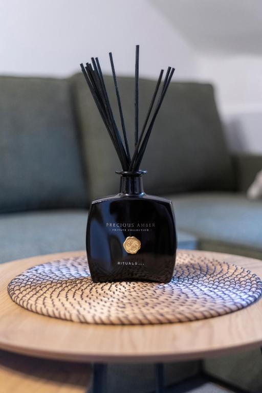 a black vase with sticks in it on a table at 20 seconds to Charles Bridge in Prague