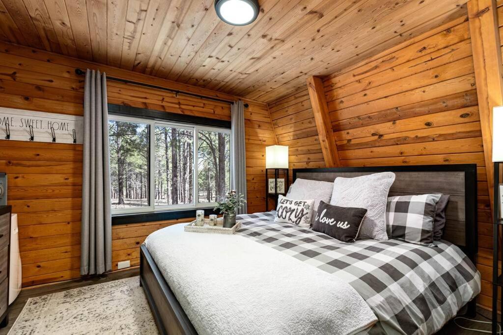 a bedroom with a bed in a wooden room at Grand Canyon Cabin! One hour and 10 minutes to the South Entrance! in Williams