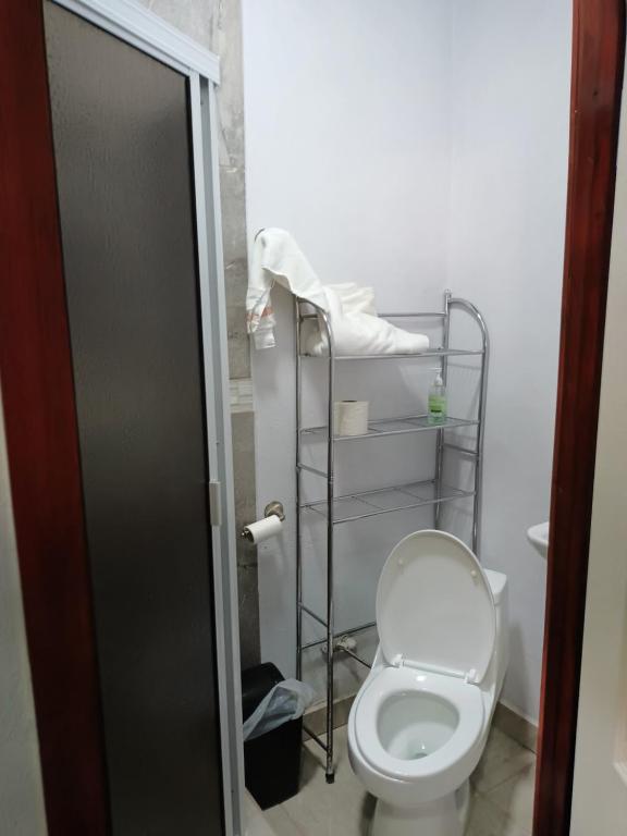 a bathroom with a toilet and a towel rack at Apartamentos Rosarito.!! Con Vista al Mar ! in Rosarito