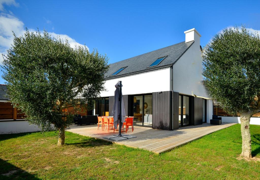 a large white house with a deck and trees at Villas du Domaine de la Pointe de Kerhostin in Saint-Pierre-Quiberon