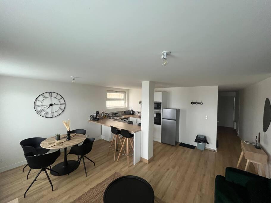 a kitchen and living room with a table and chairs at T3 Orléans charmant avec parking centre-ville in Orléans
