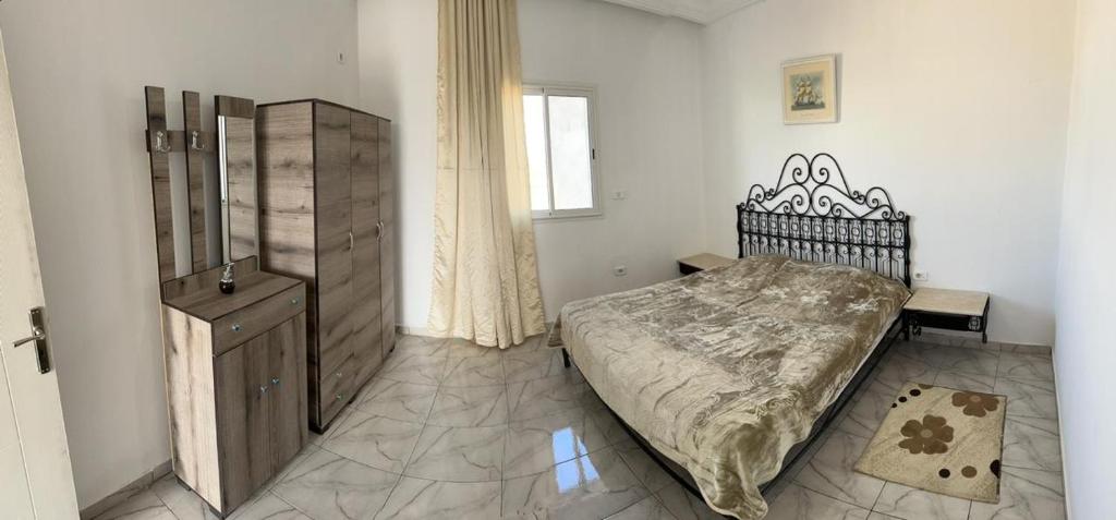 - une chambre avec un lit, une armoire et une fenêtre dans l'établissement Diar Amina, à Midoun