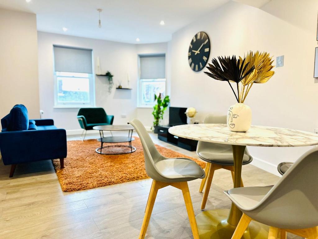 a living room with a table and chairs at Margate Spacious Apartment - 5 min walk to beach in Margate