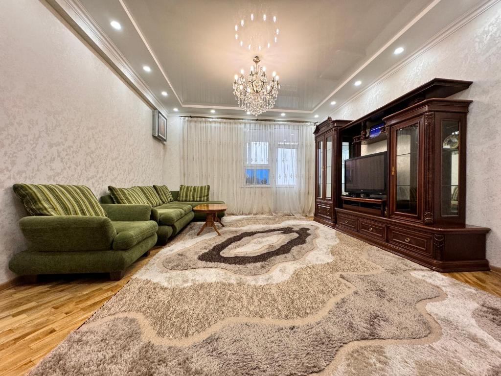a living room with a couch and a tv at Poytakht 80 Apartments in Dushanbe