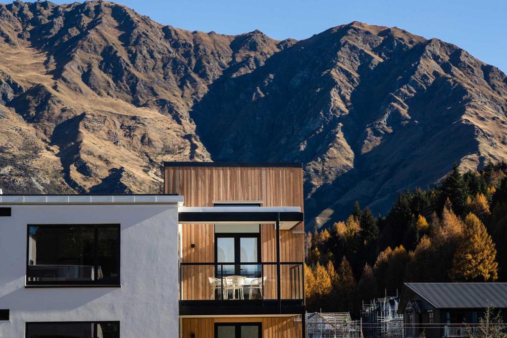 a house with mountains in the background at Residence du Parc - Luxury Apartment in Paraparaumu Beach