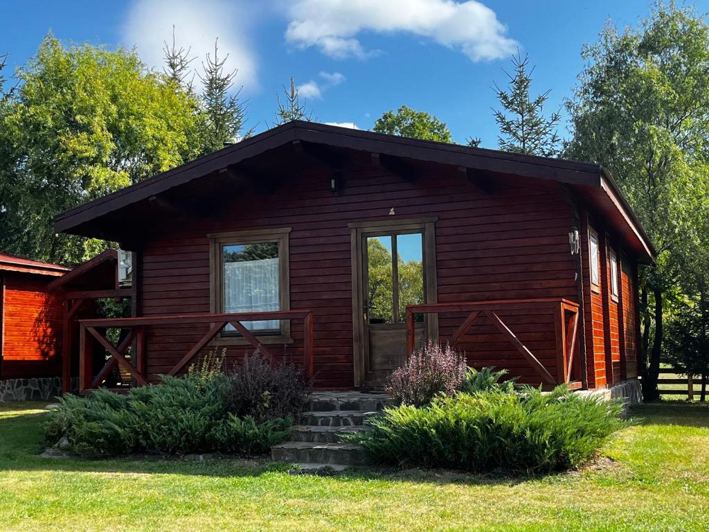 a small log cabin with a porch at Szépasszony Guest House in Vlăhiţa