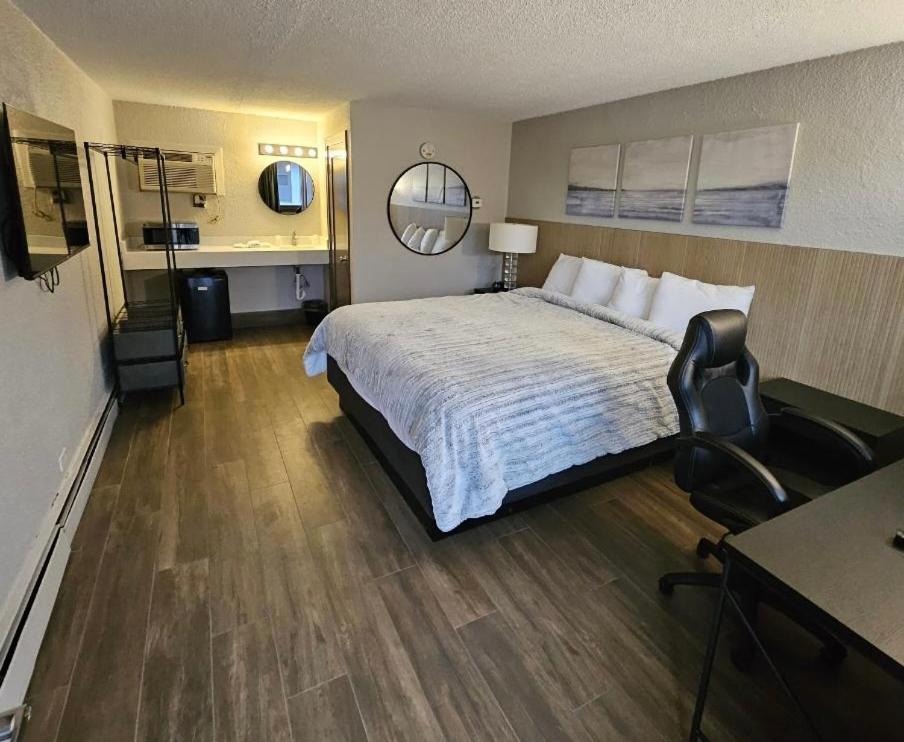 una habitación de hotel con una cama grande y una silla en Stone Creek Inn, en Worth