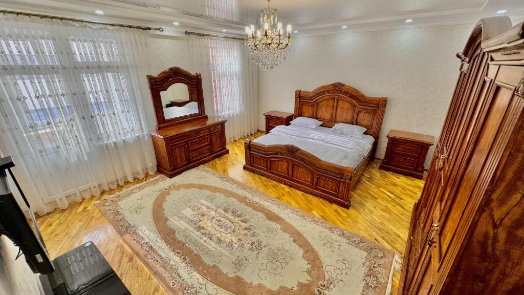 een grote slaapkamer met een bed en een spiegel bij Poytakht 80 Apartments in Doesjanbe