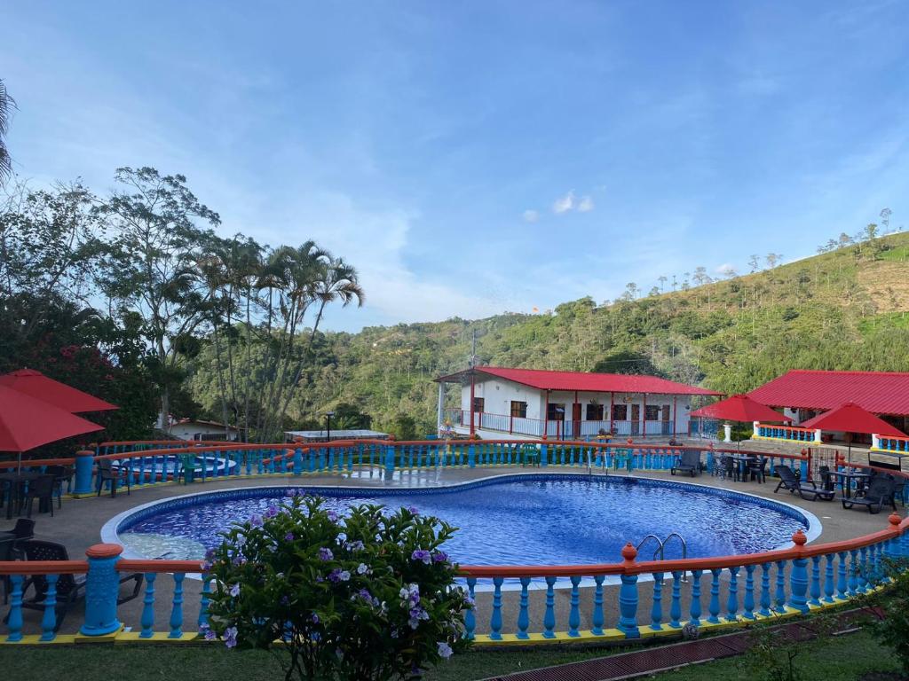 a large swimming pool with a building in the background at Hotel Cafetero Valparaíso in La Vega
