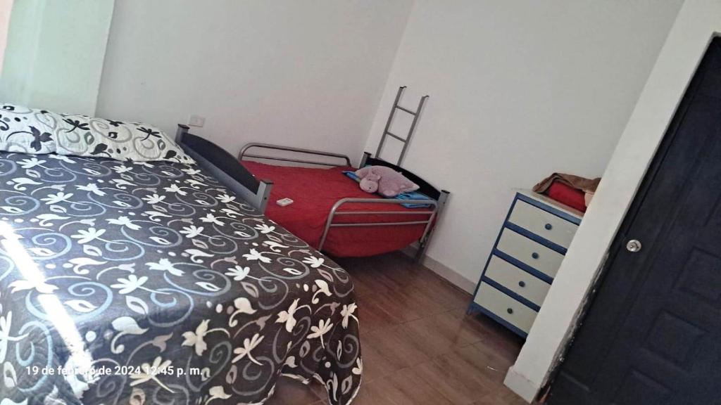 ein Schlafzimmer mit einem Bett und einer Kommode mit einem Koffer in der Unterkunft La casa de Mamá in Coatzacoalcos