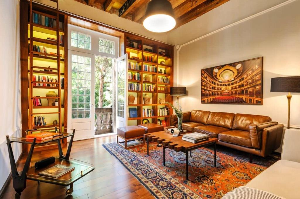 sala de estar con sofá de cuero y mesa en Amazing Casa Wynwood in Roma Norte en Ciudad de México
