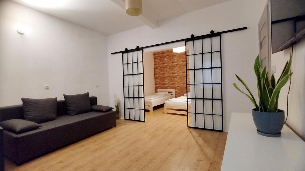 a living room with a couch and a bedroom at Urban Nest Apartments Szewska 21 in Krakow