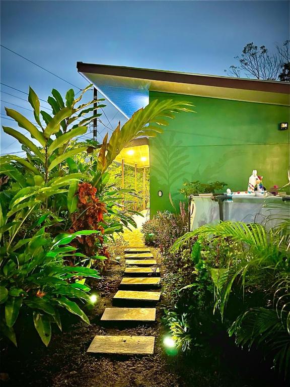 a garden with a pathway in front of a green building at Vacation Home Bartenderluisch in Fortuna