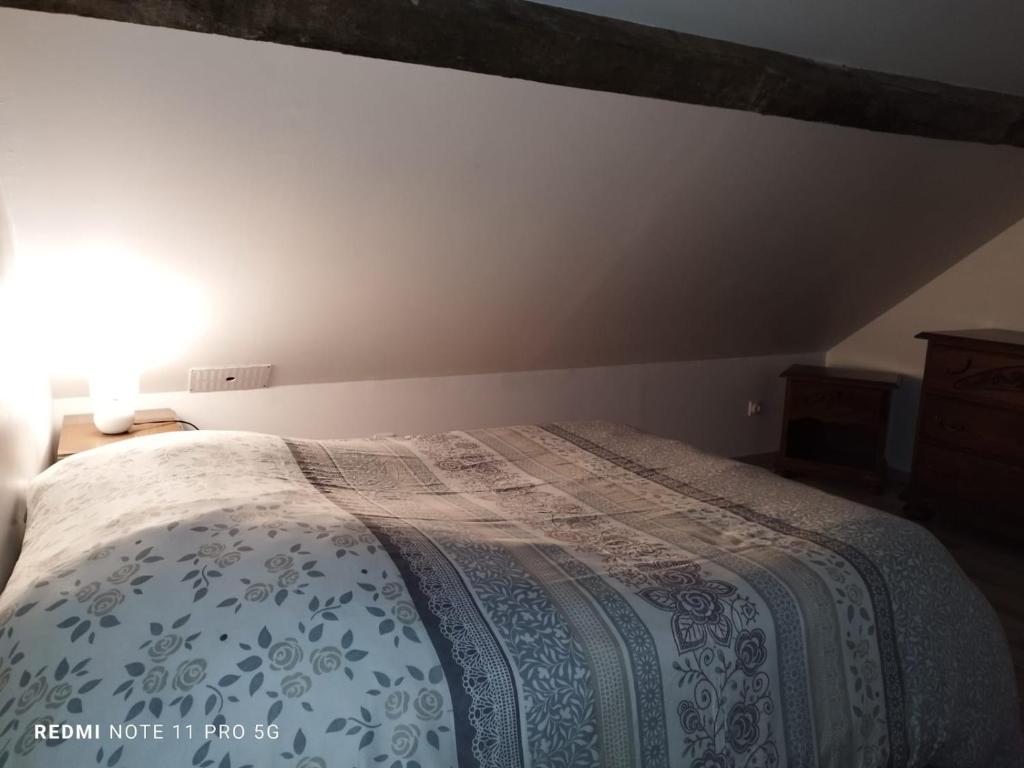 a bedroom with a bed with a comforter on it at La casa en el campo A 20 minutes de Zoo Beauval &amp; 8 minutes de la flamme olympique à Valençay in Vicq-sur-Nahon