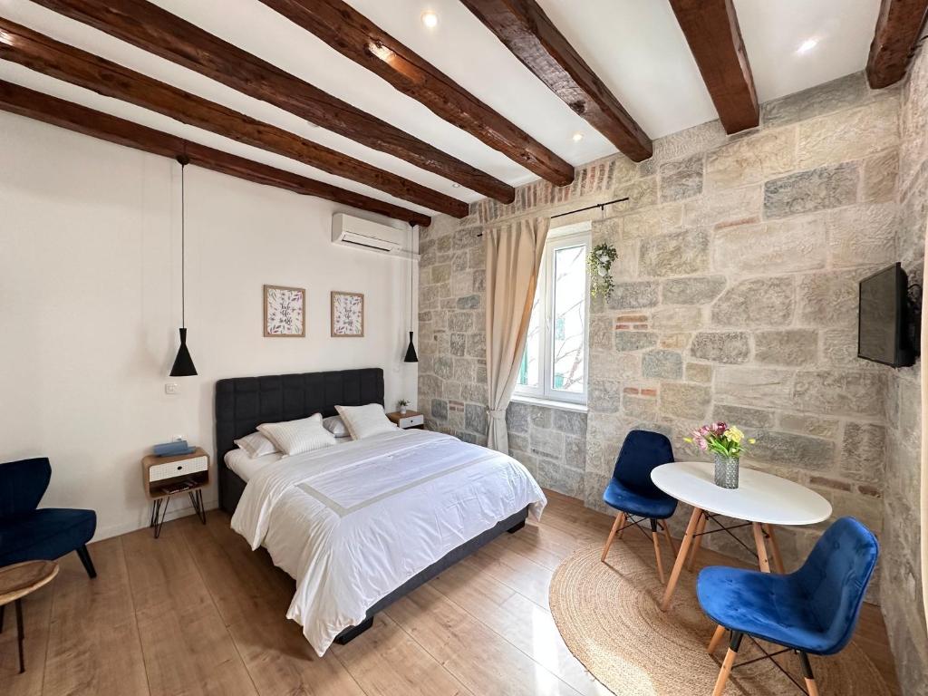 - une chambre avec un lit et un mur en pierre dans l'établissement Agora, à Split