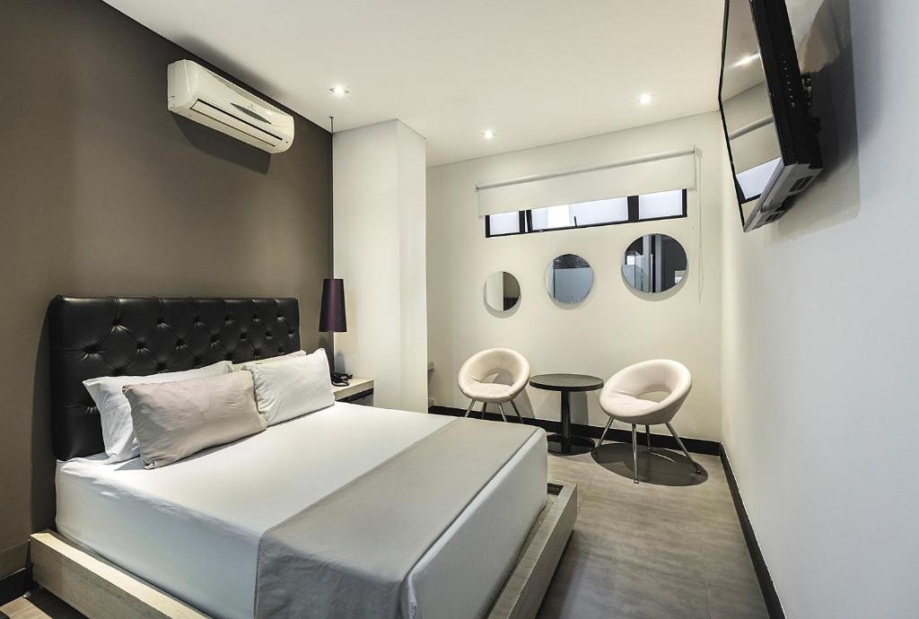 a bedroom with a bed and a tv and a table at Hotel 47 Medellin Center in Medellín