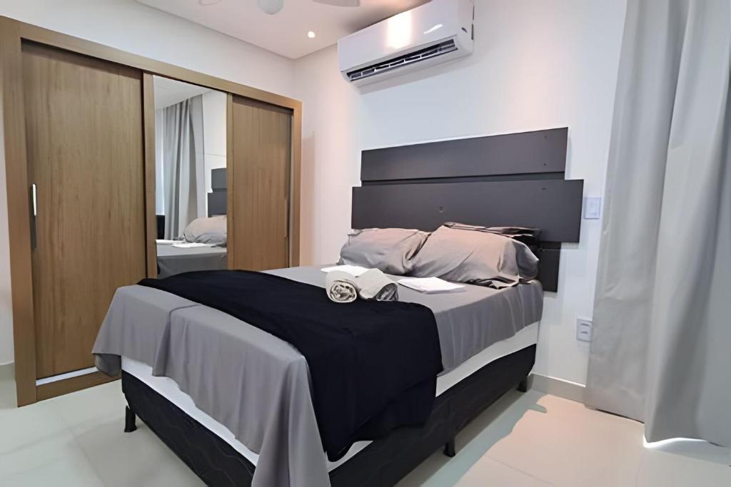 a bedroom with a large bed and a mirror at LINDOS LOFTS PRÓXIMO AO LITORAL SUL in Parnamirim