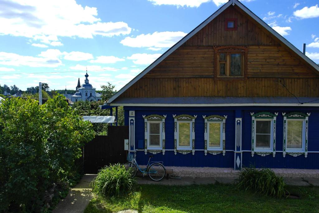 a blue house with a bike parked in front of it at Guest House Varvarinskiy in Suzdal