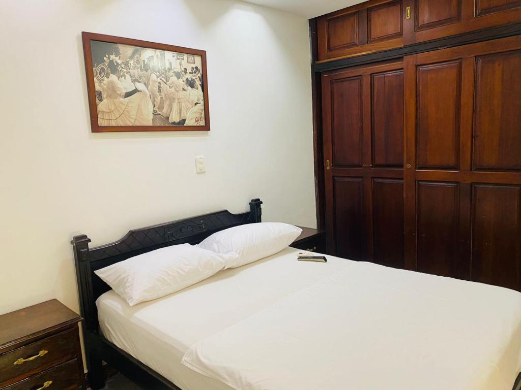 a bedroom with a bed and a wooden door at CASA MORALES in Santa Fe de Antioquia